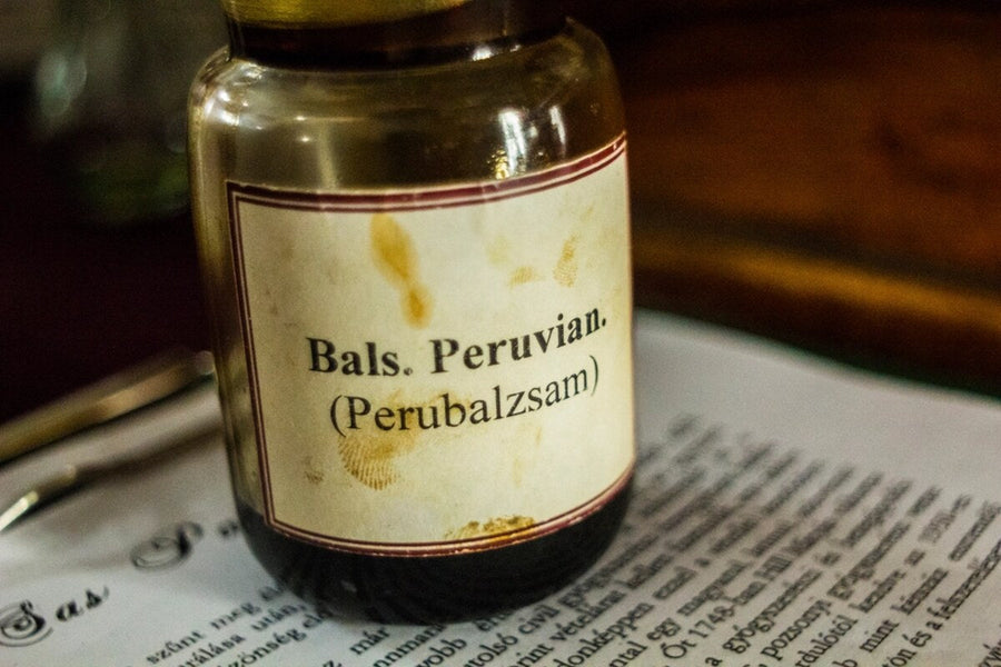 Old glass apothecary jar with a printed label resting on a page of text