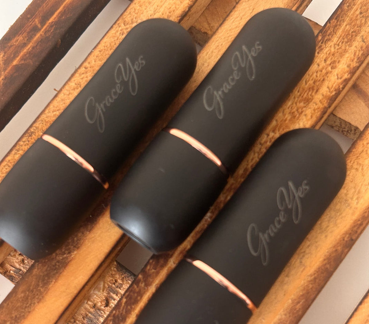 Three GraceYes lipstick cases in matte black with rose-gold band